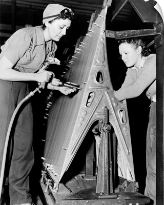 Two women riveting a piece of machinery at an American bomber plant during World War II