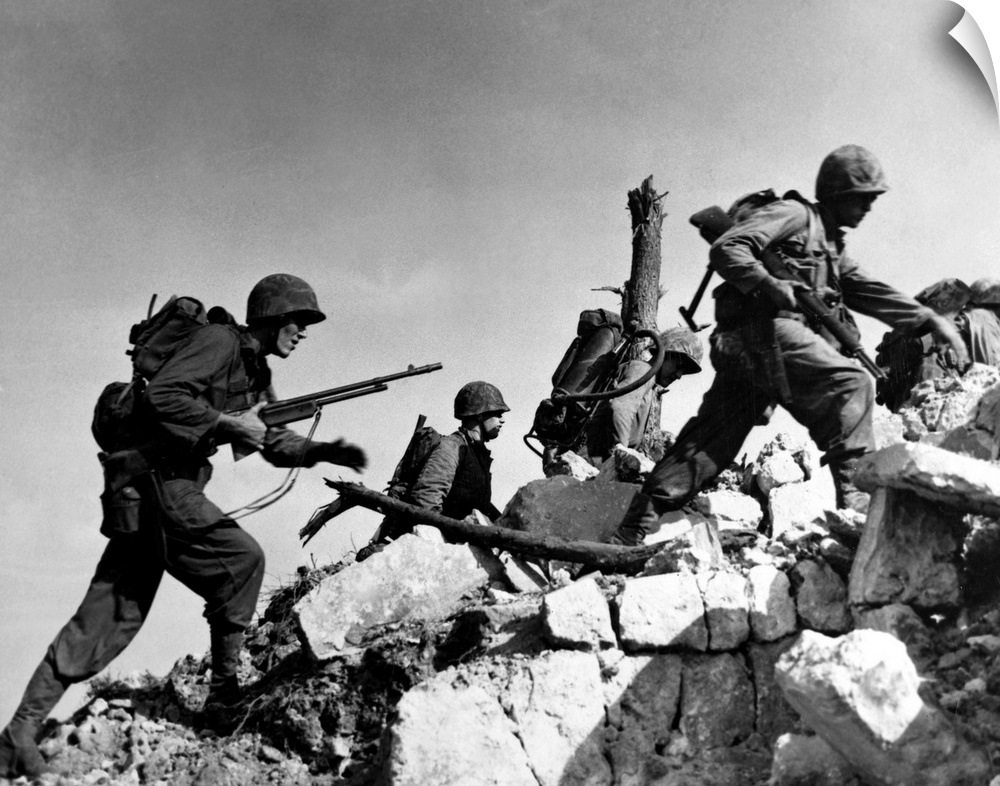 U.S. Marines hurdle a stone wall during the Battle of Okinawa, 1 April 1945.
