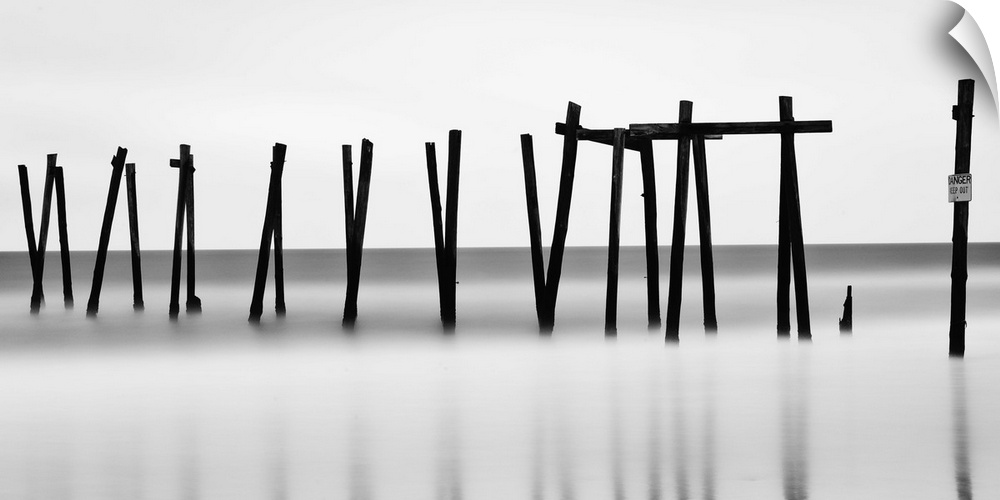 Old wooden pilings from a long-gone pier standing in the hazy ocean, Ocean City, New Jersey.