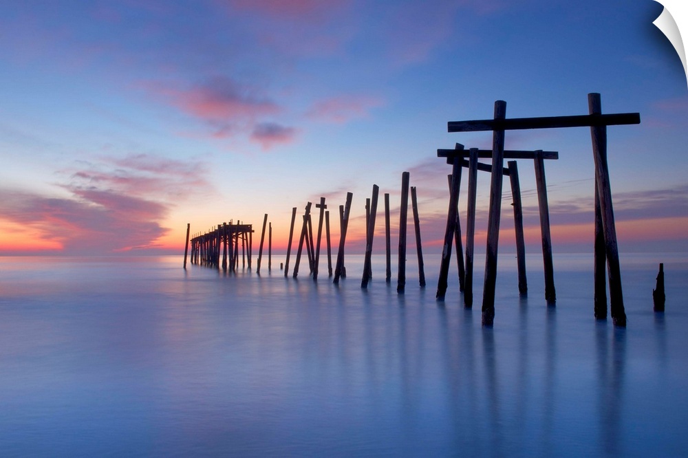 Old wooden pilings from a long-gone pier in the sea off of Ocean City, New Jersey, at dawn.