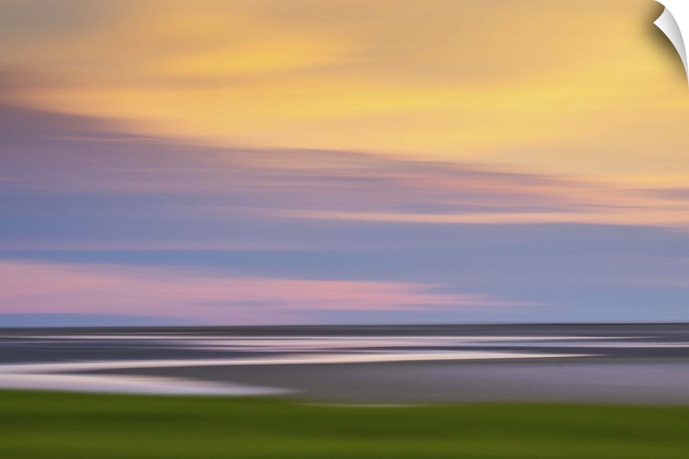 Blurred image of the Atlantic coast at sunset, with a pastel cloudy sky.