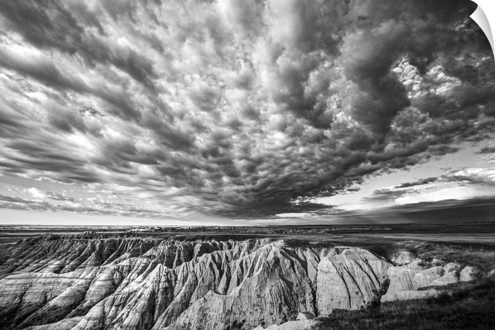 Black and white photo of striking clouds over rock formations in the South Dakota Badlands.