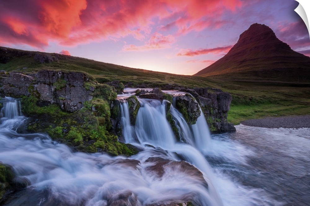 Vivid light on clouds at dusk over a waterfall near Kirkjufell, Iceland.