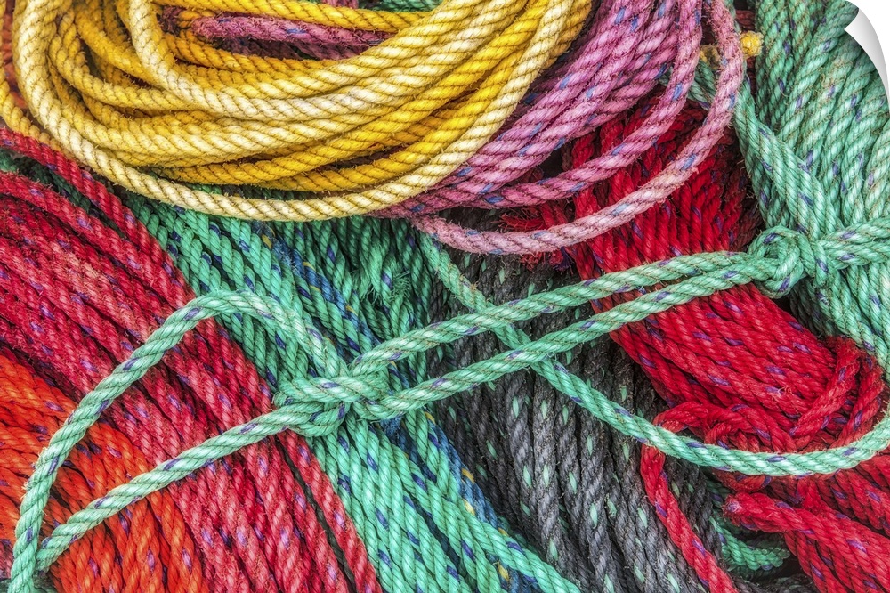 Yellow, green, and red ropes laying in a pile at a dock in Acadia National Park, Maine.