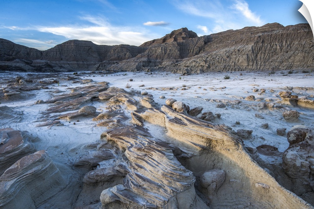 Rocky lake bed surrounded by tall rock formations in Badlands National Park, South Dakota.