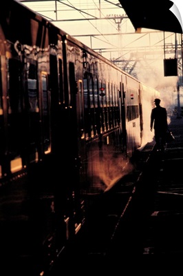 A man carrying a briefcase is about to board a train in the early morning in Japan