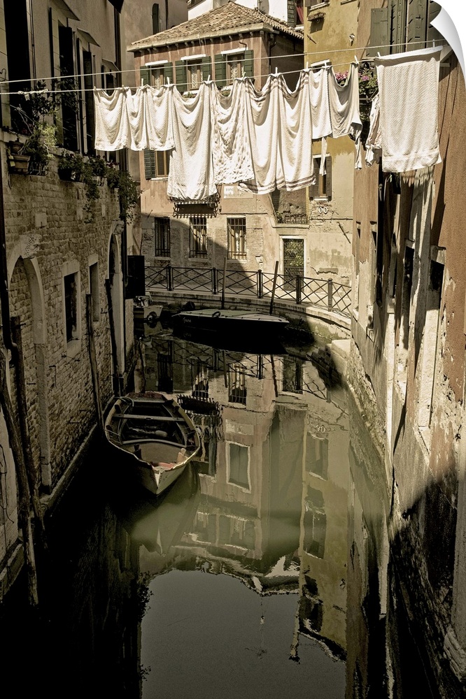 Laundry drying on a clothesline, hanging over a canal in Venice, Italy.
