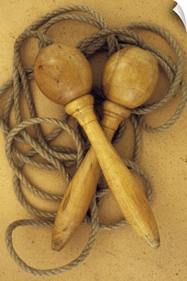 Close up of traditional skipping rope with wooden handles lying on antique paper