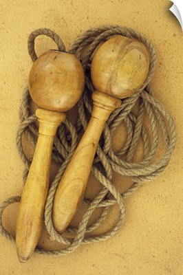 Close up of traditional skipping rope with wooden handles lying on antique paper II