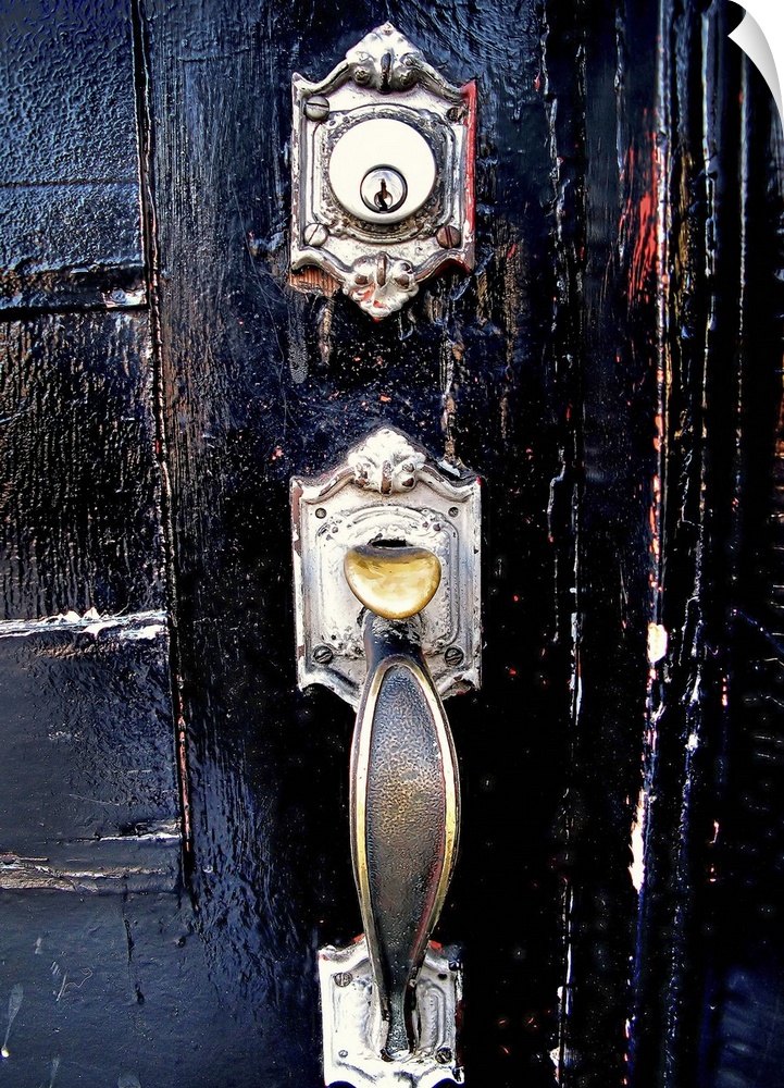 A silver door knocker on a black door