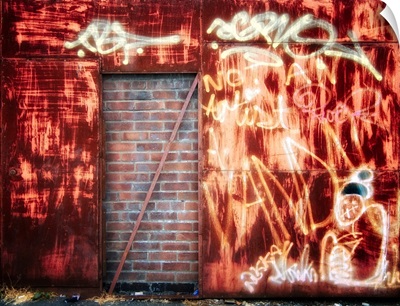 Filled in derelict door with red brickwork and graffiti