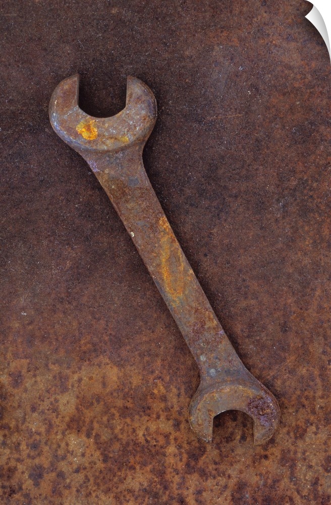 Heavy double-headed spanner lying on rusty metal sheet