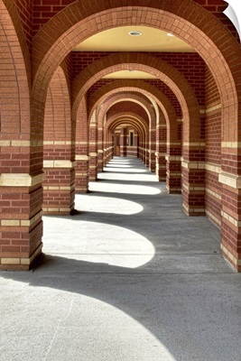 Looking along a line of brick archways with sunlight and shade
