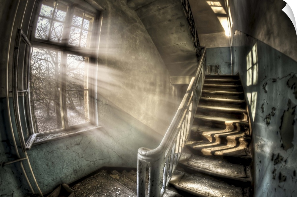 Abandoned lunatic asylum north of Berlin, Germany. Stairwell with sunlight in window.