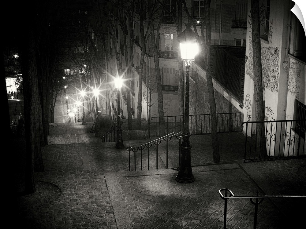 Steps on Parisian street at night with glowing street lamps
