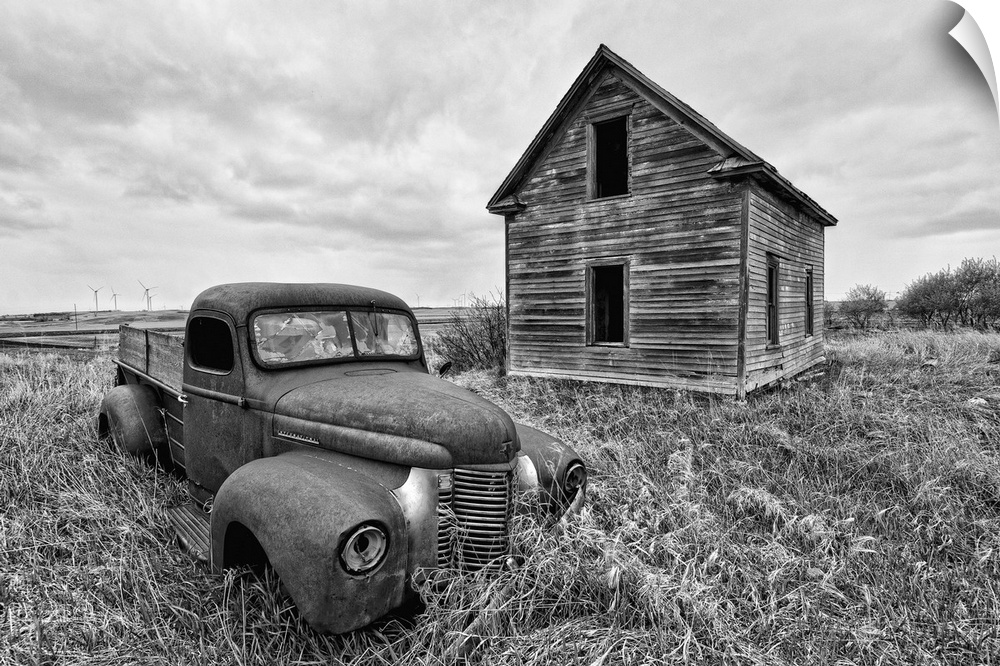 Old rusty pickup truck abandoned in rural location beside old wooden barn in Rolette County USA