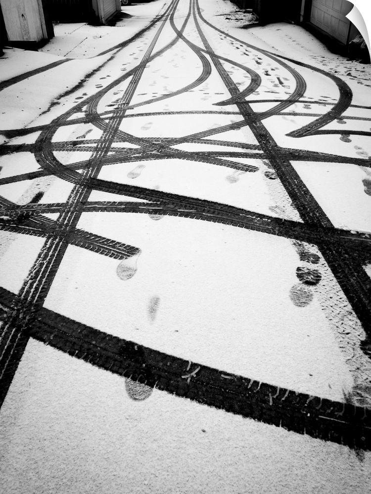 Tire tracks and foot prints in light snow.