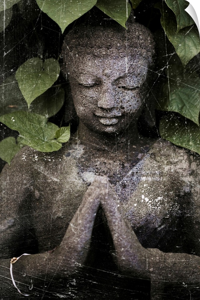 Stone Buddha under leaves