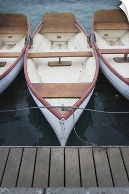 Three rowing boats moored to a jetty