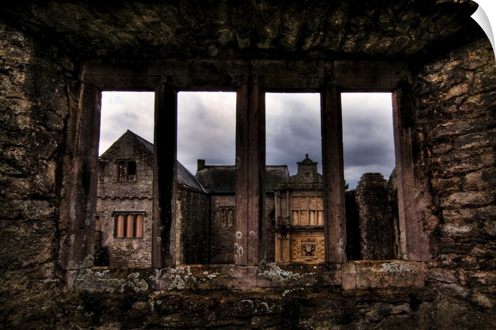 View through a stone window of ruined castle. Beaupre Castle medieval ruins in Wales.