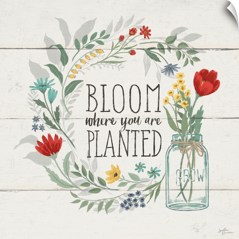 "Bloom Where You Are Planted" written inside a floral wreath on a white wood paneled background.