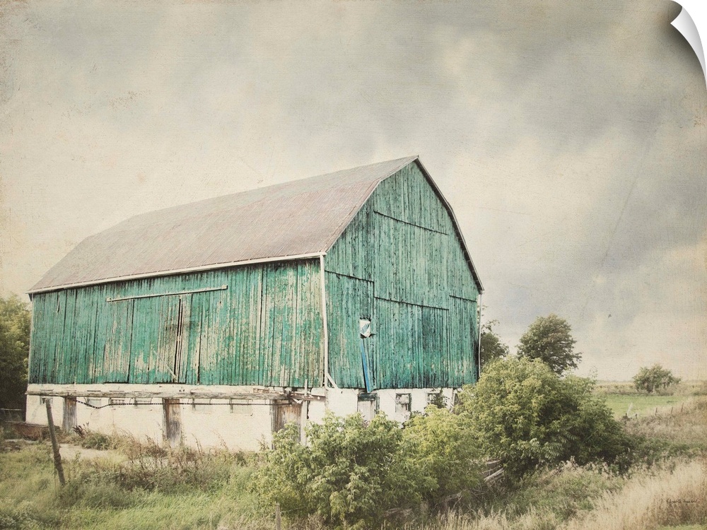 Rustic photograph with distressed edges of an aged barn in a countryside landscape.