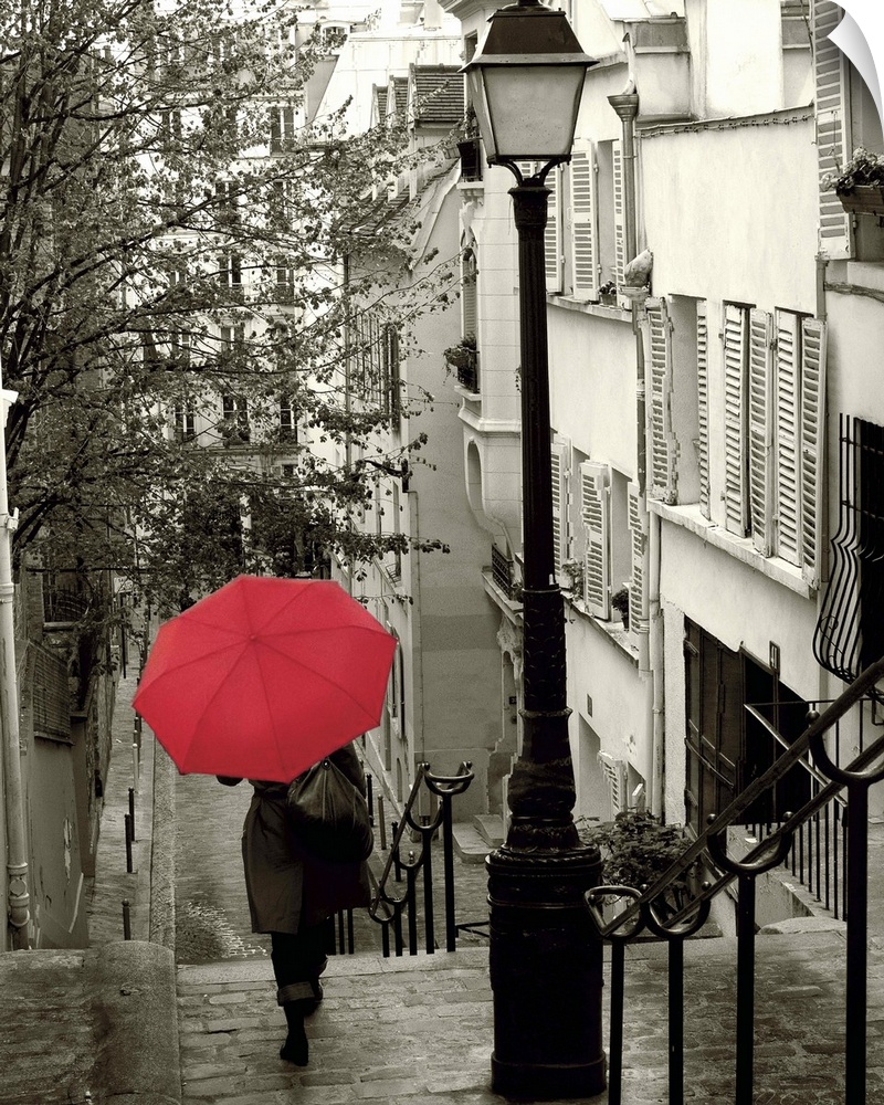 A photograph of a person walking down an empty neighborhood corridor with a red umbrella overhead.