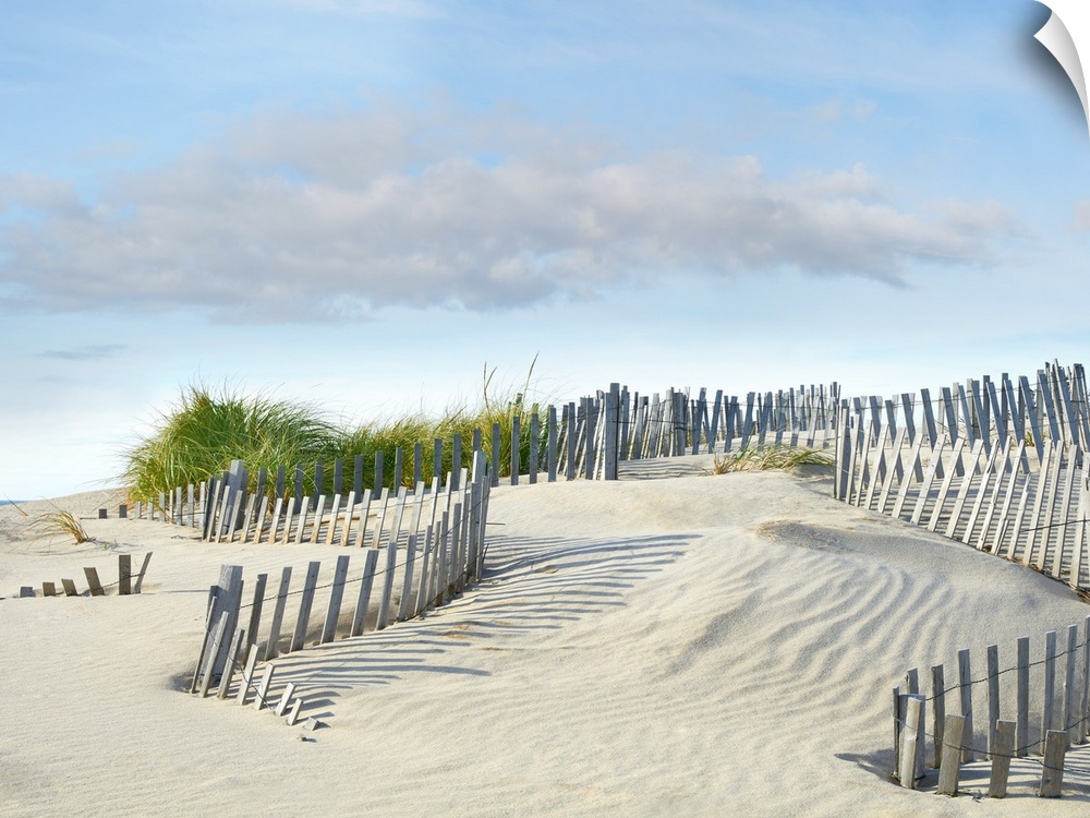 Photograph with leading lines following the wooden fence on the sand dunes at the beach.
