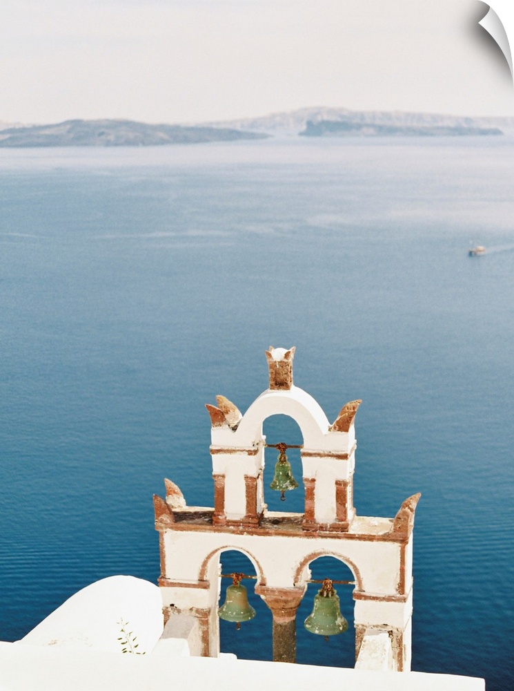 Photograph of church bell towers overlooking the ocean in the Greek city of Oia, Santorini.