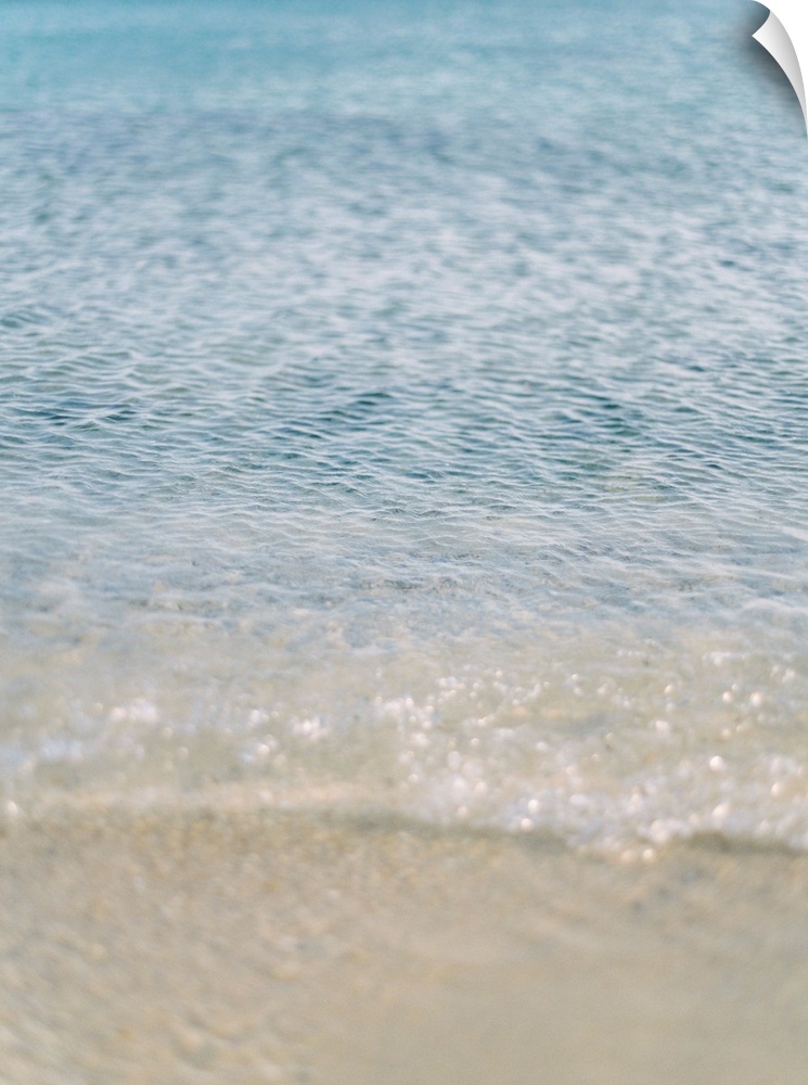 Photograph of clear ocean water lapping the sand, Corfu, Greece.