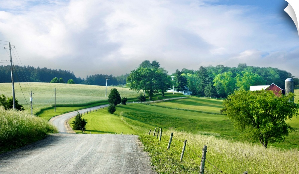 Photograph of a countryside road heading towards a red barn on the right.