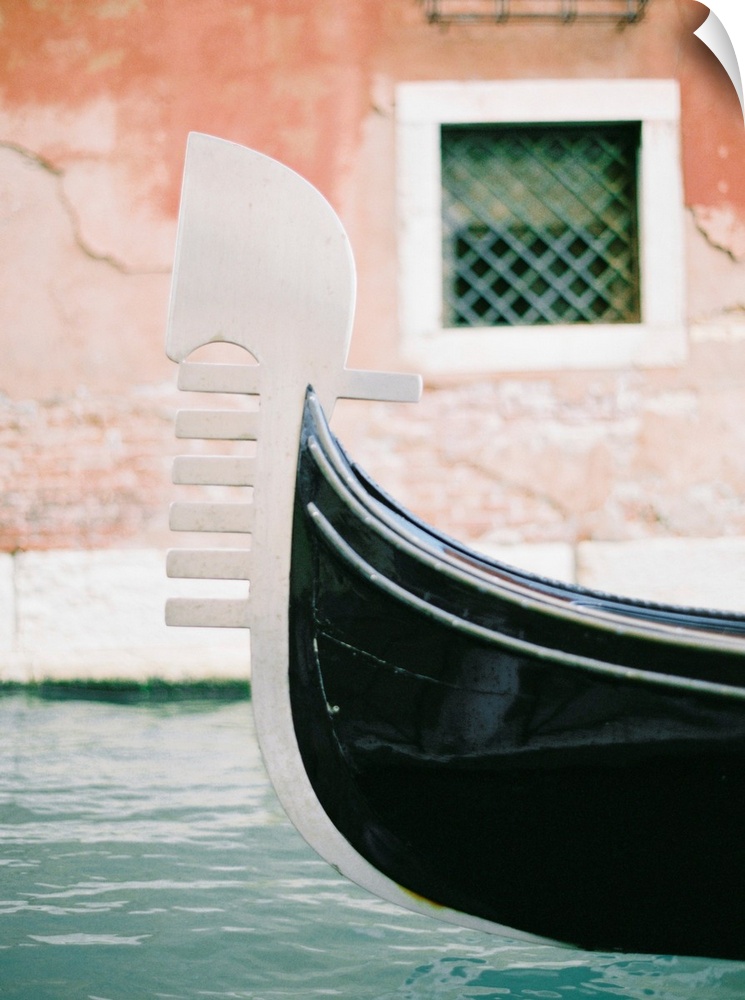 Photograph of the decoration on the end of a gondola on a canal in Venice, Italy.