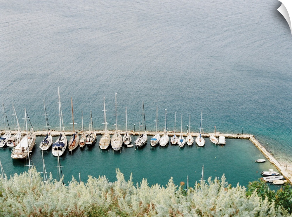 Photograph of several sailing boats moored in a simple marina, Corfu, Greece.