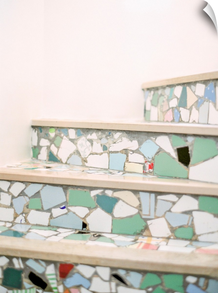 A colorful photograph of mediterranean stair risers decorated with multicolored mosaic tile fragments.