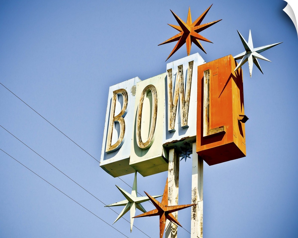 Photograph of a retro bowling sign against a clear blue sky.