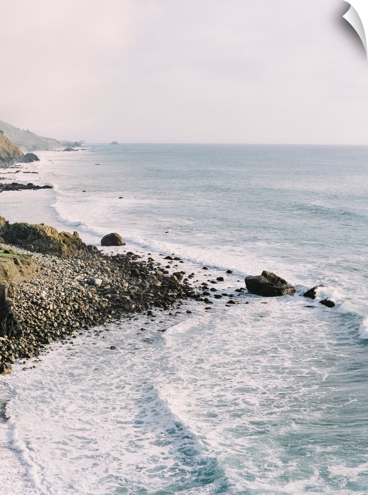 Photograph of gentle waves lapping the rocky shore of Big Sur, California.