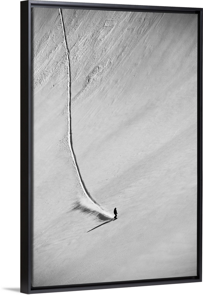 A professional, freeriding snowboarder on a wide open snowy slope making new tracks; British Columbia, Canada