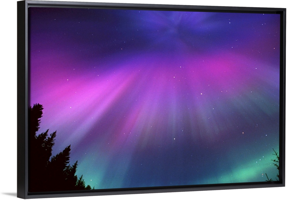 This landscape photograph captures the glow of the Northern lights and the speckles of stars beyond it.