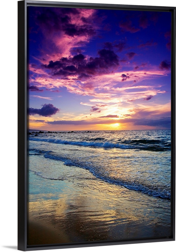 Large photograph displays the waves of the Pacific Ocean slowly coming into shore and crashing against the sandy beach of ...