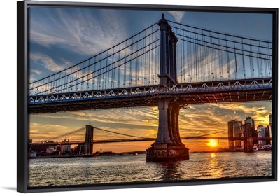 Sun setting behind Manhattan and Brooklyn Bridges; New York City