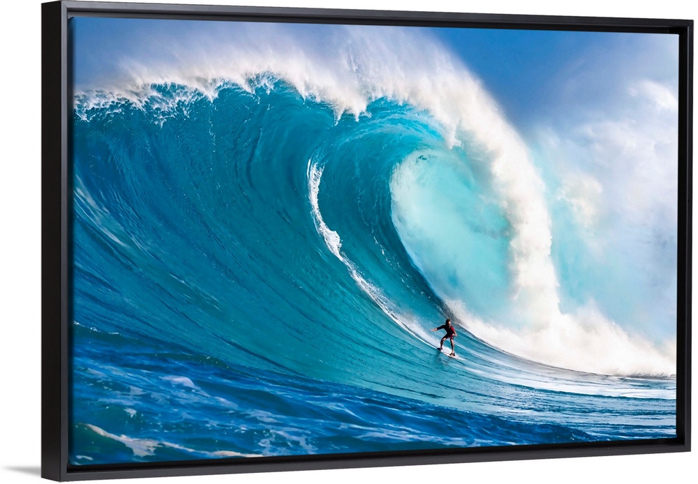 A tow-in surfer drops down the face of Hawaii's big surf at Peahi (Jaws) off North shore Maui; Maui, Hawaii, United States...