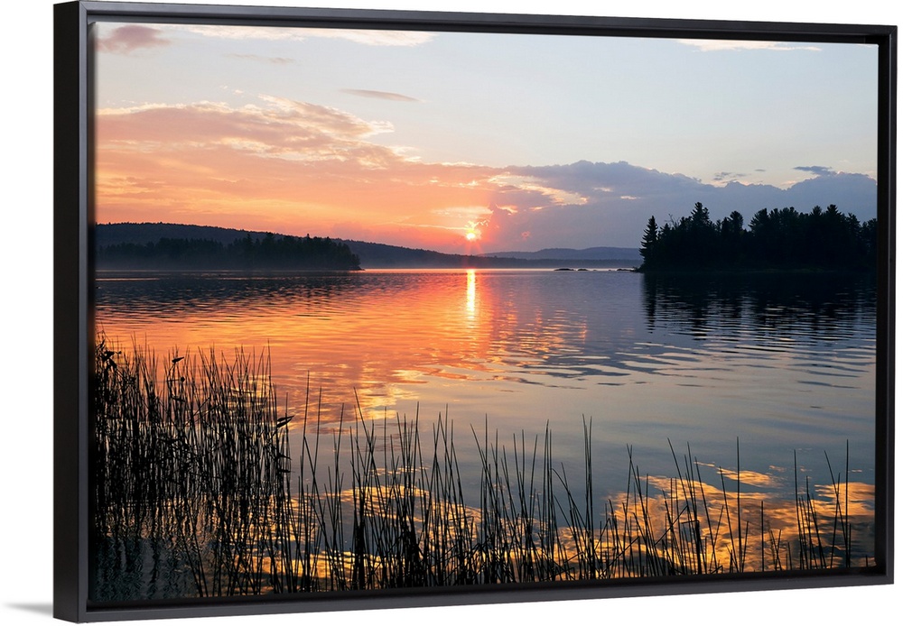 Canvas print of a peaceful lake with a sunset reflected onto it.