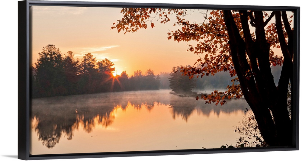 Big Canvas photo of a tranquil lake at sunrise with forests around it bathed in warm sunlight.