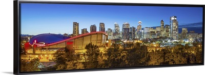 Canada, Alberta, Calgary, Skyline of downtown Calgary and Saddledome illuminated at dusk