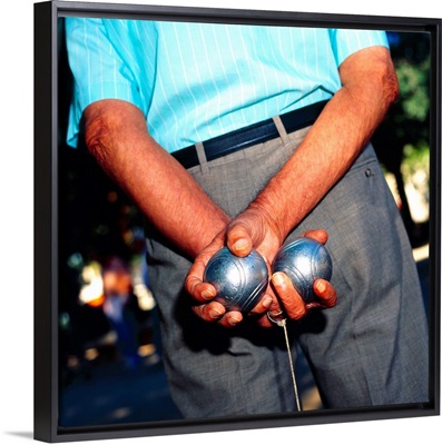 Spain, Barcelona, Man holding two boules behind his back