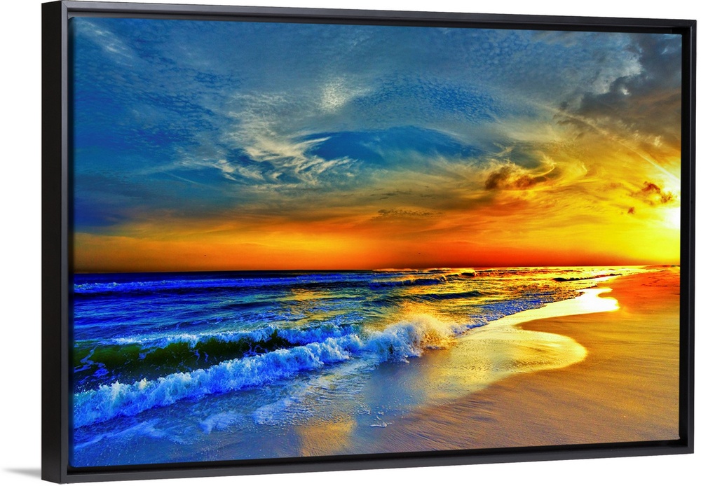 A sandy beach before a bright burning red sunset.  Waves crash onto the sandy sea shore. Landscape taken on Navarre Beach,...