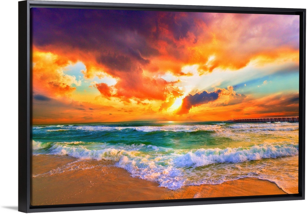 A red, orange and purple sunset on the beach. Beautiful ocean waves roll onto the sea shore.