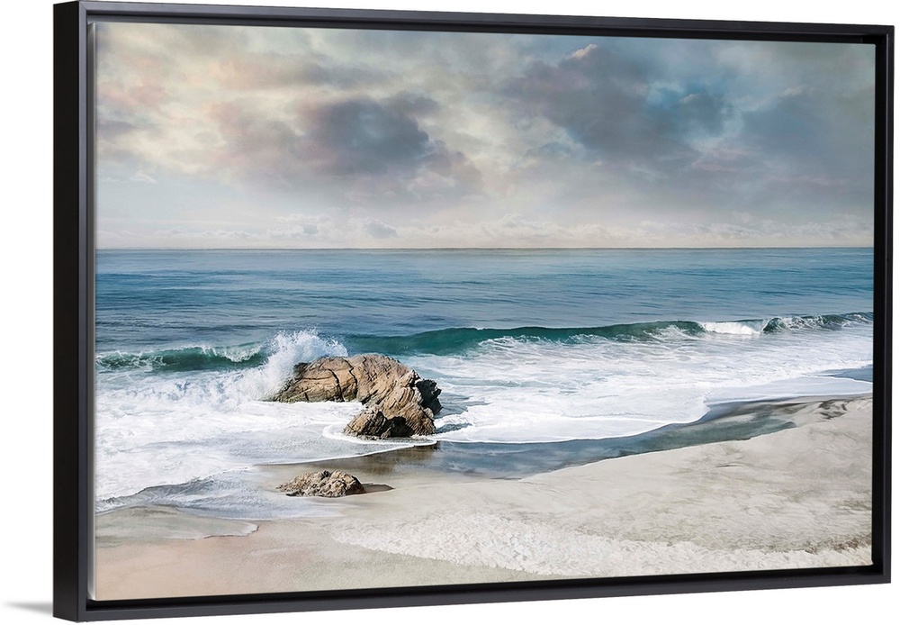 Landscape photograph of waves crashing onto a rock on the sandy shore.