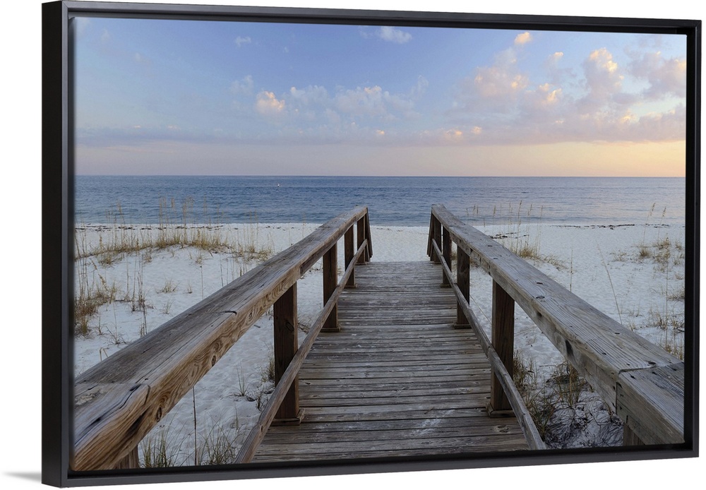 Photograph of a wooden walkway leading to the sandy beach with a Pensacola sunset