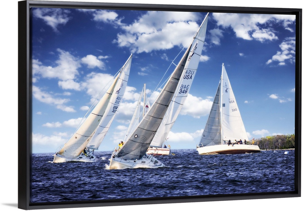 Three white sailboats on the water under a cloudy blue sky.